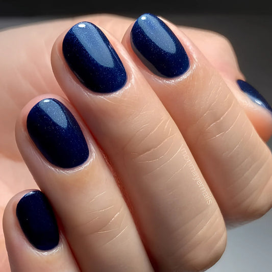 A close-up of a hand with CND Shellac Midnight Swim manicure
