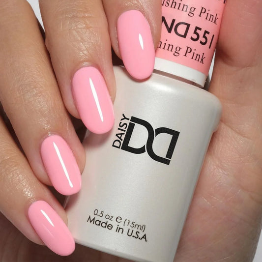 Hand wearing DND Blushing Pink #551 gel polish, showing the soft pink nude tone with coral warmth on the nails