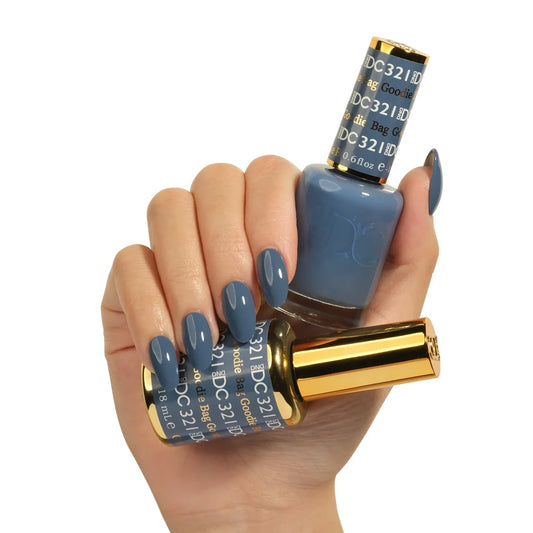 a manicured hand holding DND DC Goodie Bag #321 duo set with matching gel polish and nail lacquer in denim blue shade
