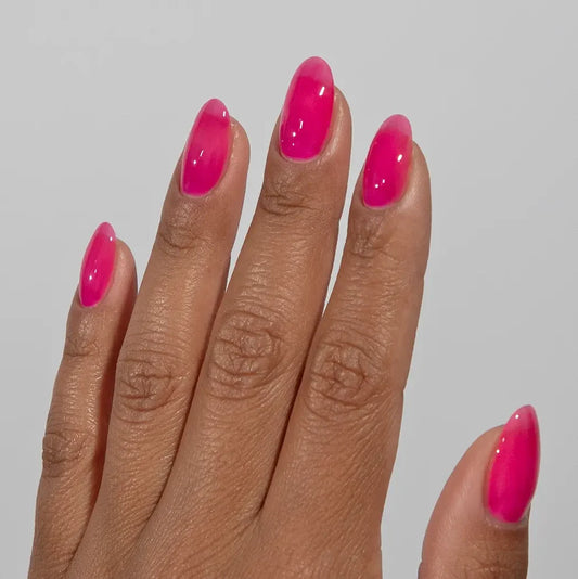 Manicured hand wearing DC Jelly 011 Hot Pink jelly gel polish to show the bold watermelon hot pink finish in natural light