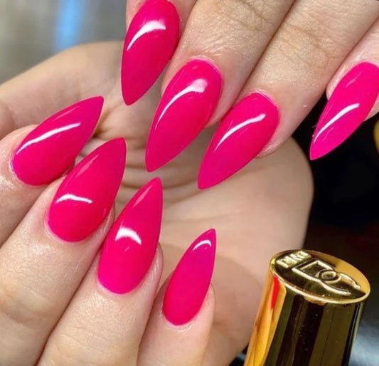 Hand with bright pink nails and a gold lipstick container.