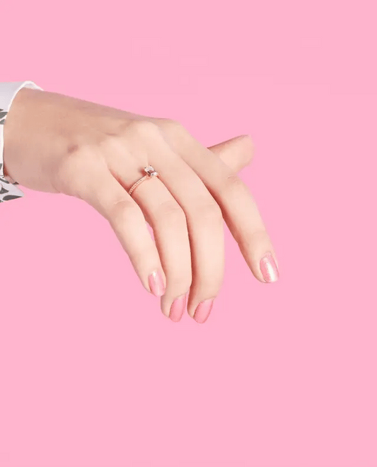 Manicured hand showing OPI R44 pink glitter gel polish applied to fingernails