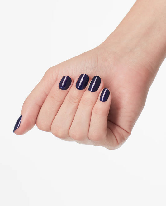 opi turn on the northern lights gel manicure hand with dark blue nail polish on a white background