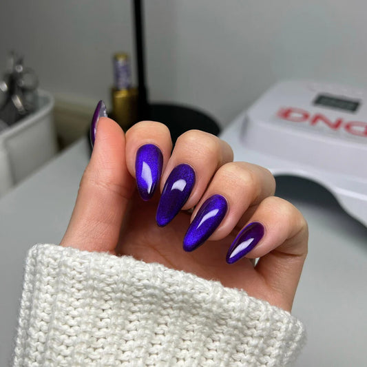 Purple cat eye nails on hand wearing DND DIVA Puma Purple 06 manicure hands