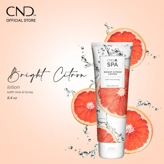 CND Bright Citron lotion tube with grapefruit slices on a light pink background