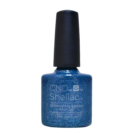 A bottle of CND Shellac Shimmering Shores nail polish in a sparkling medium blue shade, featuring a black cap, on a plain white background.