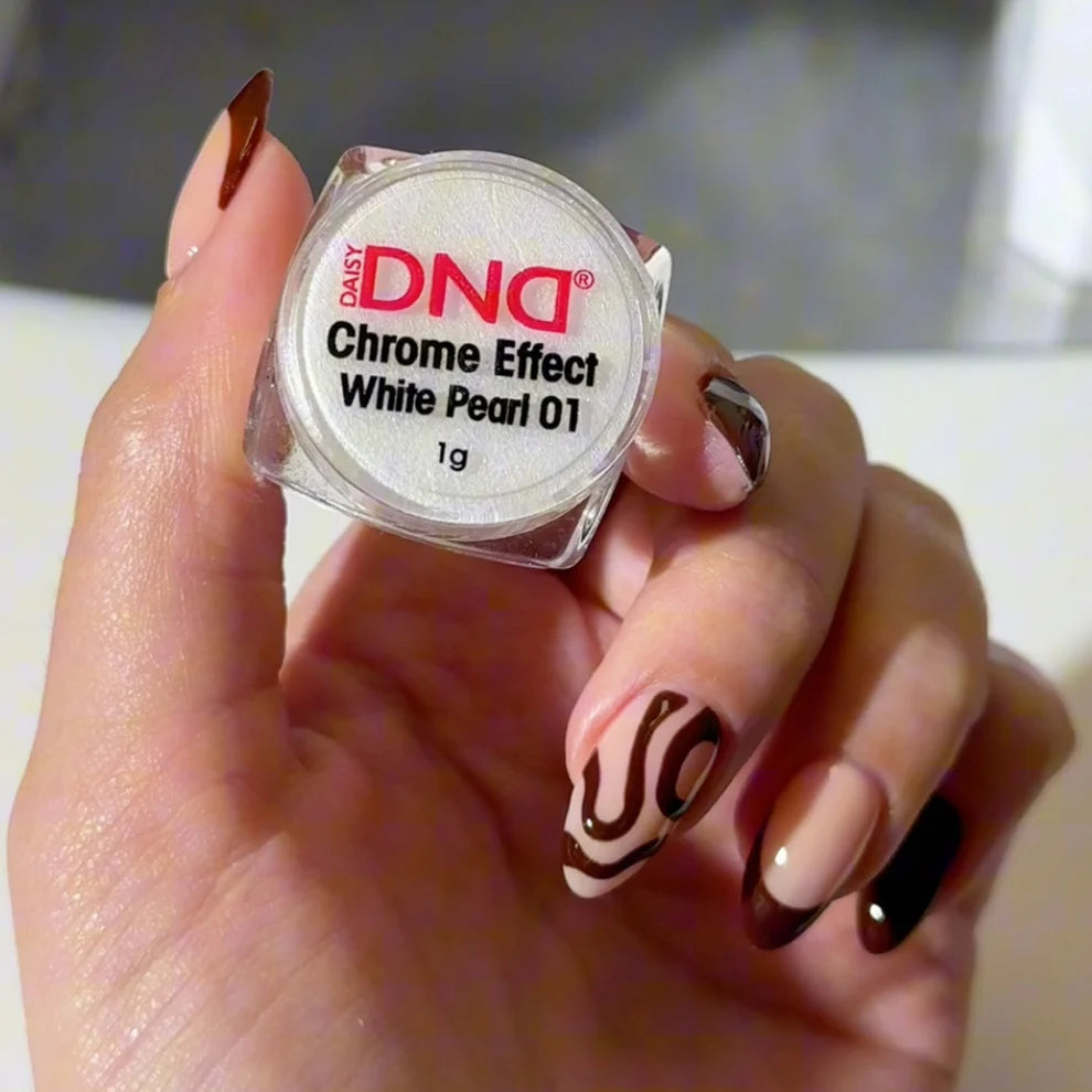 Hand holding a container of DND Chrome Effect White Pearl 01 nail powder with zebra patterned nails.