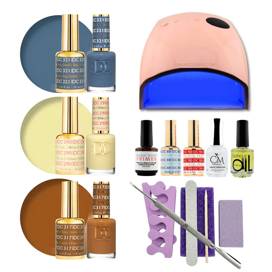 A gel polish starter set arranged on a white background, including three shades of nail polish with color circles, a white and rose-gold UV lamp, several small bottles, a purple nail file tray, a metal nail file, and two purple polishing pads. Visible branding includes DND on the polish bottles
