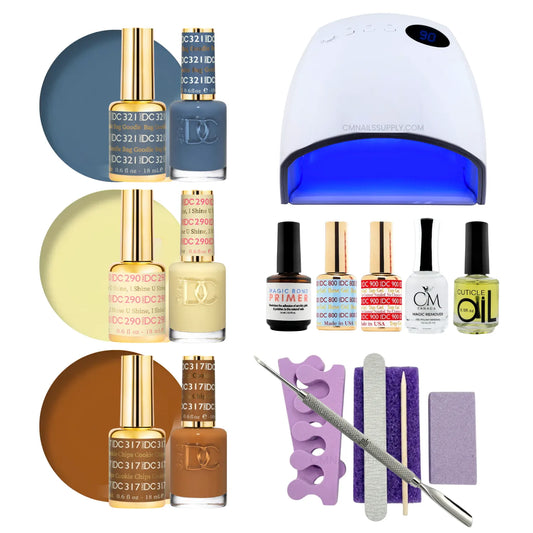 A gel polish starter kit arranged on a white background, including three shades of DC DND gel nail polish (blue-gray, pale yellow, warm brown), a UV nail lamp, primers, CM nail monomer, cuticle Oil, a nail file, a purple buffer pedicure kit, and metal tools.