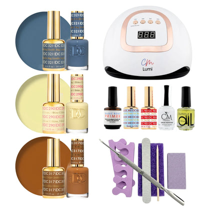 A gel polish starter set arranged on a white background, including three shades of nail polish with color circles, a white and rose-gold UV lamp, several small bottles, a purple nail file tray, a metal nail file, and two purple polishing pads. Visible branding includes DND on the polish bottles