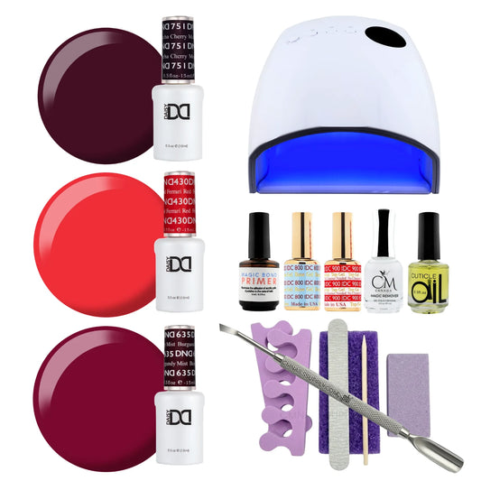 A gel polish starter kit arranged on a white background, including three shades of DND gel nail polish (cherry mocha, ferrari red and burgundy mist), a UV nail lamp, primers, CM nail monomer, cuticle Oil, a nail file, a purple buffer pedicure kit, and metal tools.