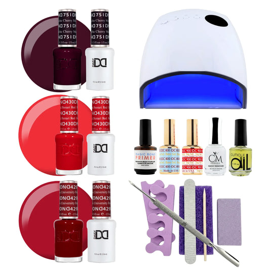 A gel polish starter kit arranged on a white background, including three shades of DC DND gel nail polish (cherry mocha, ferrari red and university red), a UV nail lamp, primers, CM nail monomer, cuticle Oil, a nail file, a purple buffer pedicure kit, and metal tools.