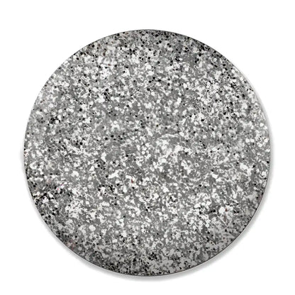 A circular swatch of silver glitter with black flecks, presented on a clean white background.