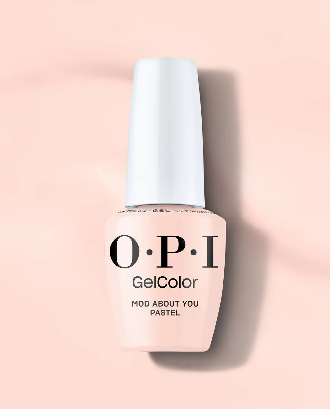 A bottle of OPI GelColor Mod About You Pastel Gel Polish in the shade Mod About You Pastel, featuring a pale peach-pink color and a white cap, set against a matching soft peach-pink background.