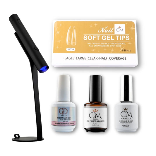 Set of gel polish starter kit products including a UV lamp, base coat, primer and bonder, and top coat bottles, and nail tips a white background