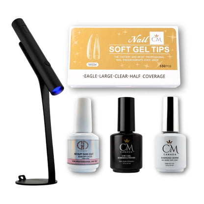 Set of gel polish starter kit products including a UV lamp, base coat, primer and bonder, and top coat bottles, and nail tips a white background