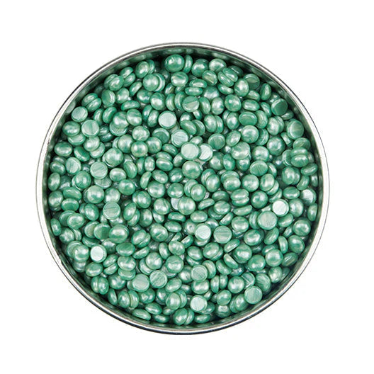 Satin Smooth Green wax beads in a metal bowl on a white background