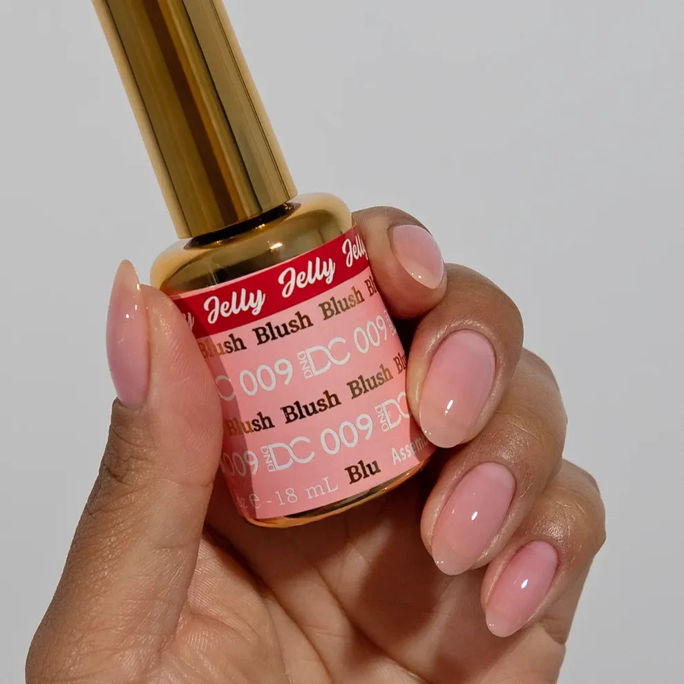 Manicured hand with dark skin tone wearing DC Jelly 09 Blush jelly gel polish in a soft pale pink finish