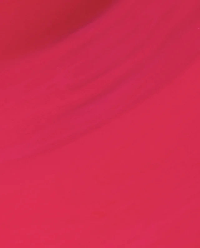 A close-up of a solid, vibrant magenta pink fabric texture with soft, diagonal folds.