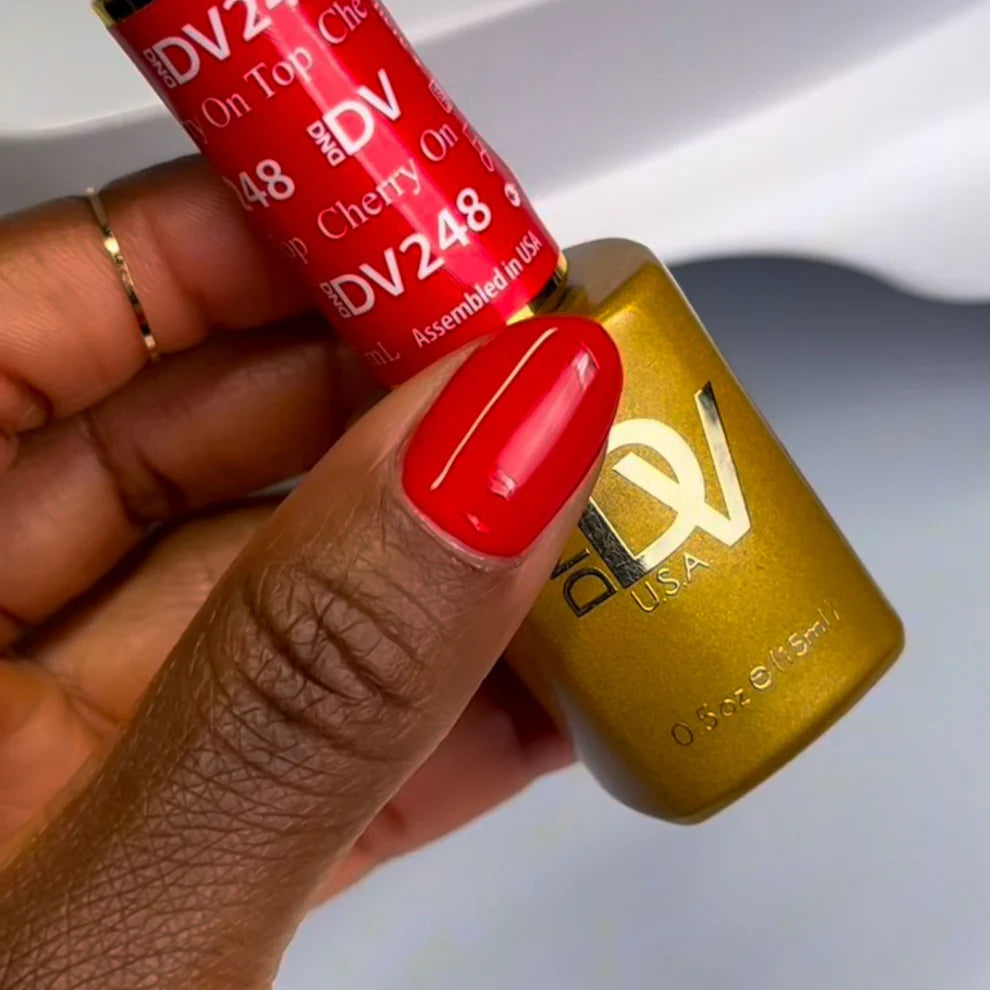 Manicured hand wearing DND red nail polish in Cherry On Top shade
