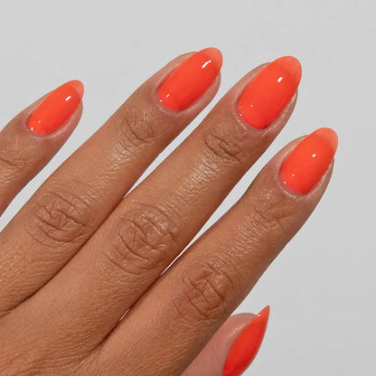 Manicured hand wearing DC Jelly 07 Citrus jelly gel polish to show the tangy fiery orange finish in natural light
