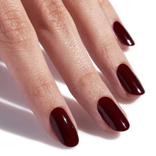 Full manicure in CND Shellac Oxblood on a hand, highlighting the rich dark blood red color on all nails.