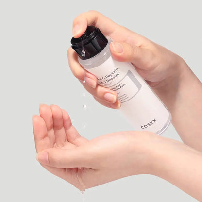 Close up of the COSRX peptide serum bottle and pump dispenser applied on hand