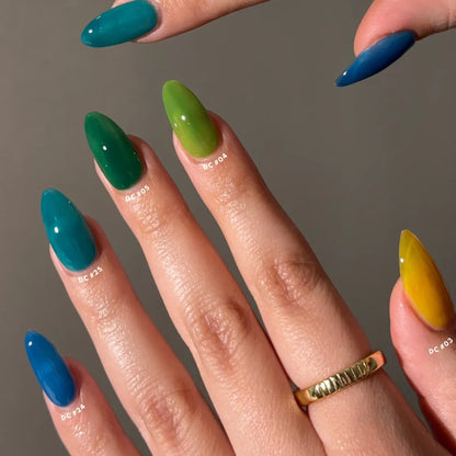 Close-up of a hand with multicolored nails against a neutral background