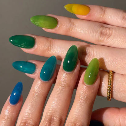 Close-up of a hand with multicolored nail polish on a neutral background