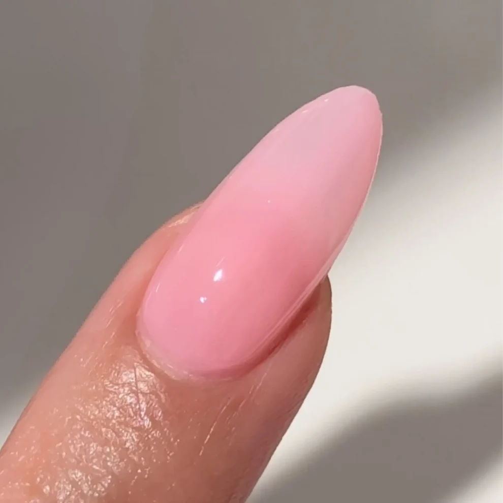 Manicured hand with DC Jelly 09 Blush jelly gel polish applied to show the finished salon style manicure