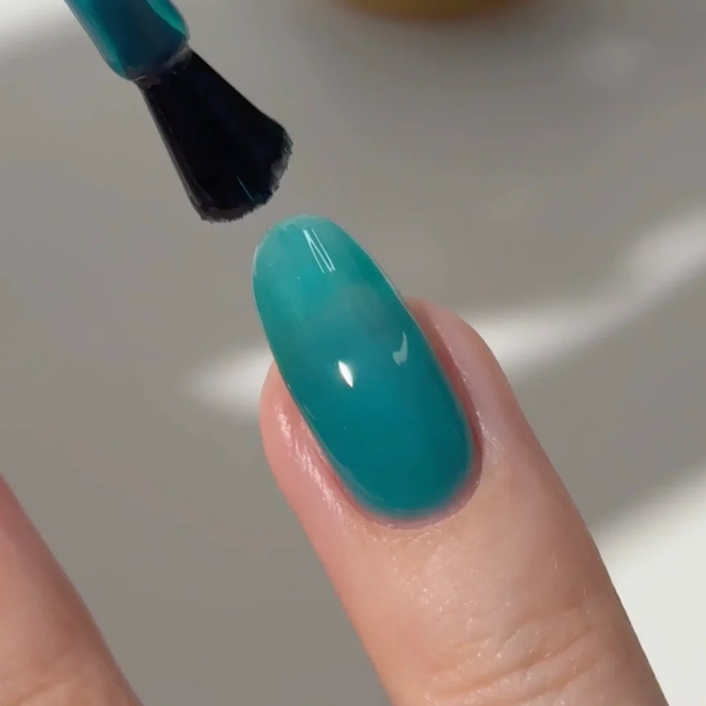 Manicured hand with DC Jelly 024 Jade jelly gel polish applied to show the finished salon style manicure