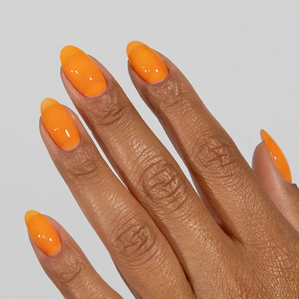 Manicured hand with DC Jelly 06 Orange jelly gel polish applied to show the finished salon style manicure