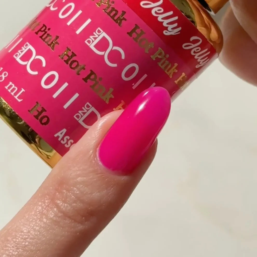 Fair skin manicured hand showing DC Jelly 011 Hot Pink jelly gel polish with a bright creamy finish