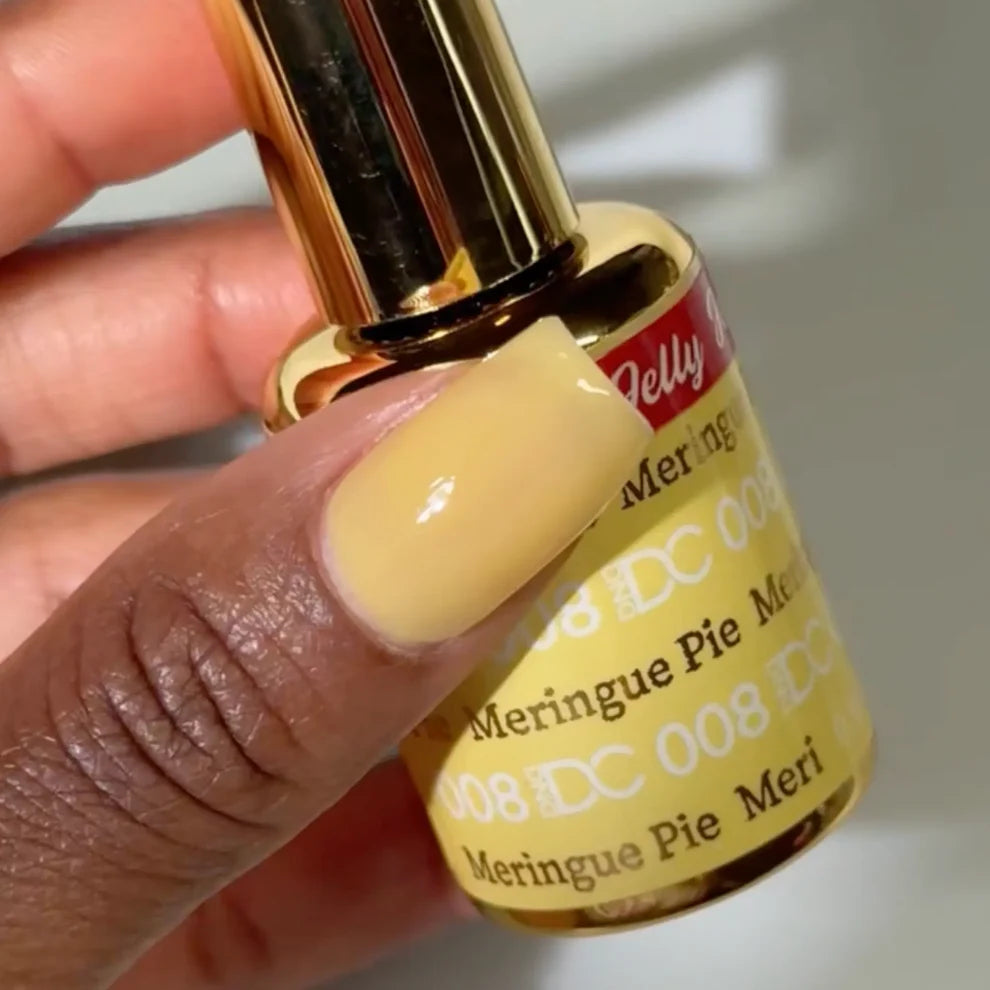 Deep skin tone manicured hand showing DC Jelly 08 Merengue Pie jelly gel polish with a whipped pale yellow finish