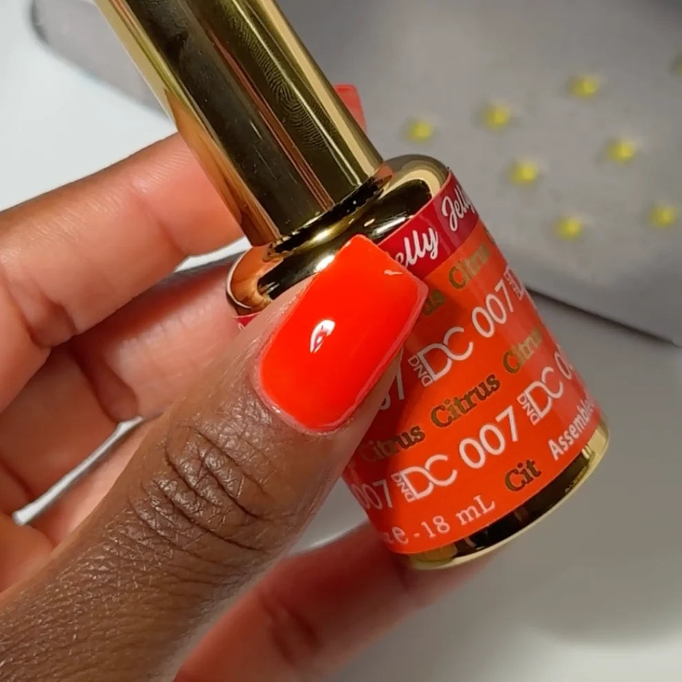 Close up of the DC Jelly nail polish bottle in the Citrus shade with brush cap and label visible