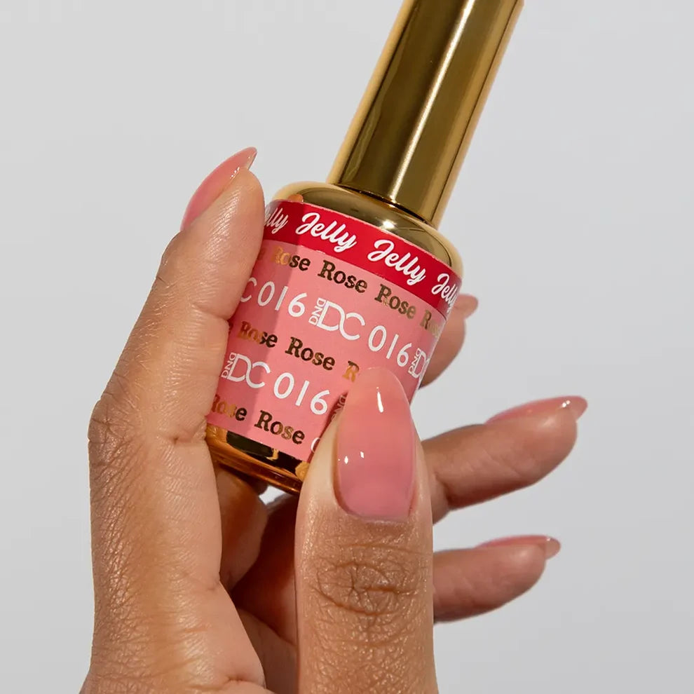 Deep skin tone manicured hand showing DC Jelly 016 Rose jelly gel polish with a petal soft pink cream finish