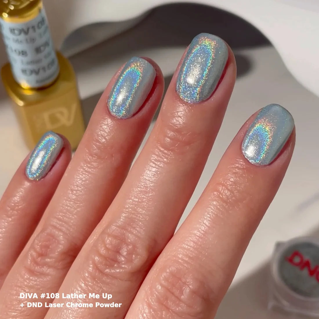 Manicured hand wearing DIVA 018 Lather Me Up sky blue pastel gel nail polish and chrome powder