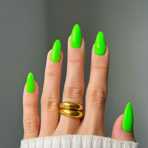Side angle view of manicured nails with DIVA #190 Tokyo Tea neon green polish in natural light