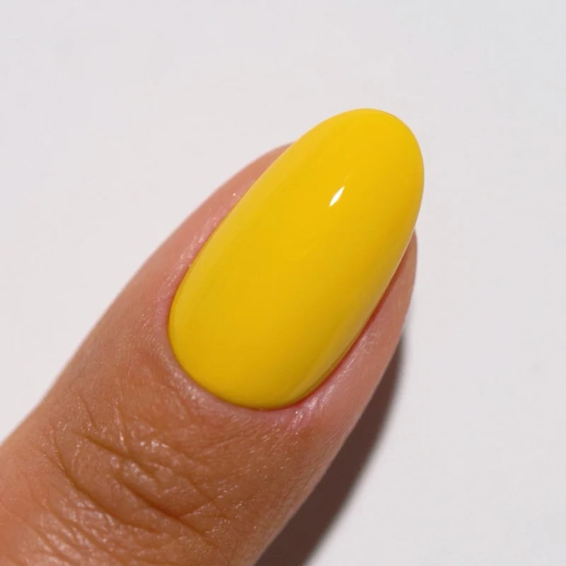 Side angle manicured finger wearing DIVA #203 Mimosa soft yellow gel polish with natural light finish