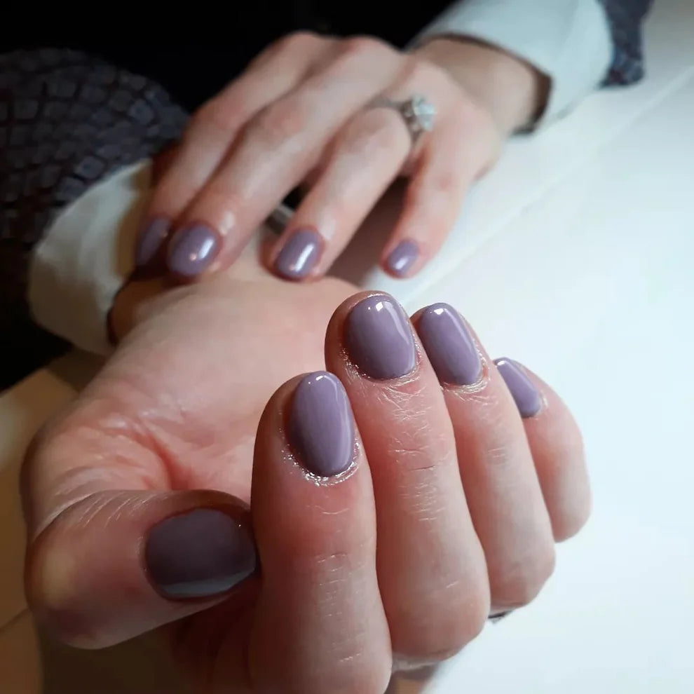 Close-up manicure showing DND Antique Purple #489 cool dusty mauve gel nail polish colour on nails.