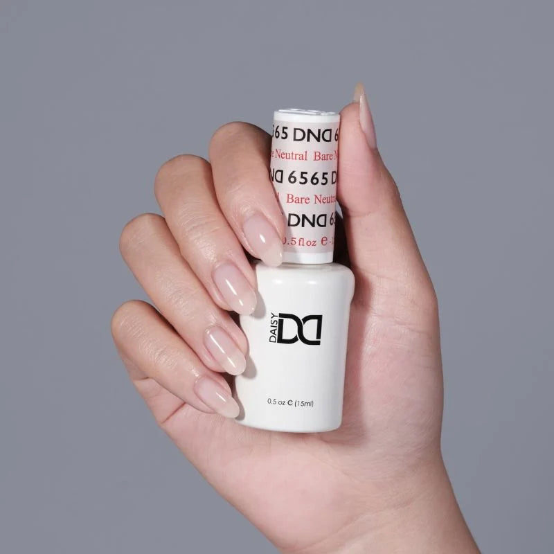Side manicure shot holding the DND Bare Neutral 2345 sheer taupe polish 