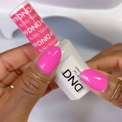 Close-up manicure showing DND Be My Valentine #499 gel polish bottle rosy-toned pink gel nail polish colour on nails.