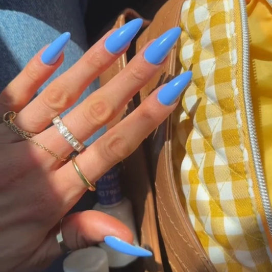 Hand wearing DND Blue Earth #575 gel polish, showing the sky blue tone with creamy gray undertones on the nails