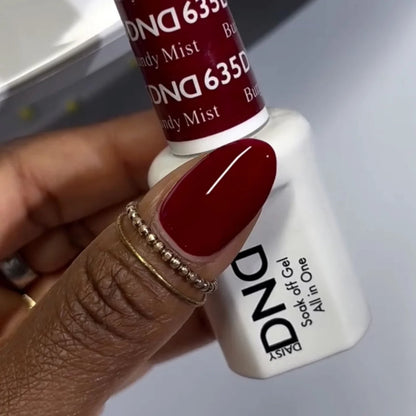 Close up of a hand wearing a DND Burgundy Mist #635 manicure with a glossy deep burgundy finish
