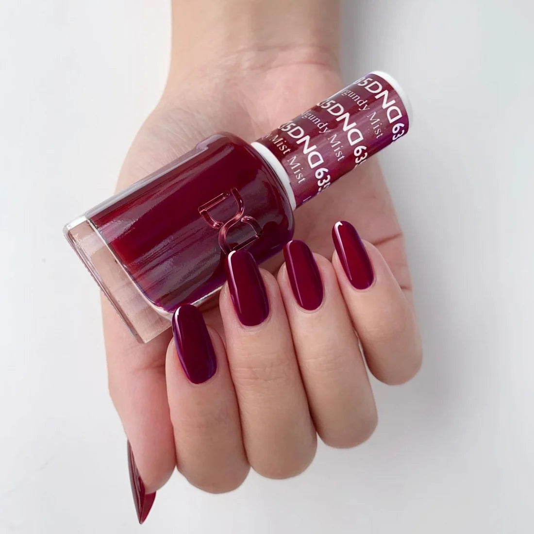 Manicure featuring DND Burgundy Mist #635 painted on natural nails in a deep burgundy tone