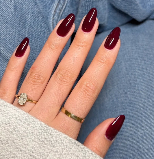 Manicure featuring DND Cherry Mocha #751 gel polish painted on natural nails in a rich cherry brown shade