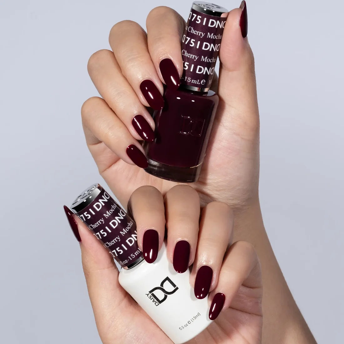 Close up of fingernails painted with DND Cherry Mocha #751 gel polish, highlighting the red purple undertone in the cherry brown color