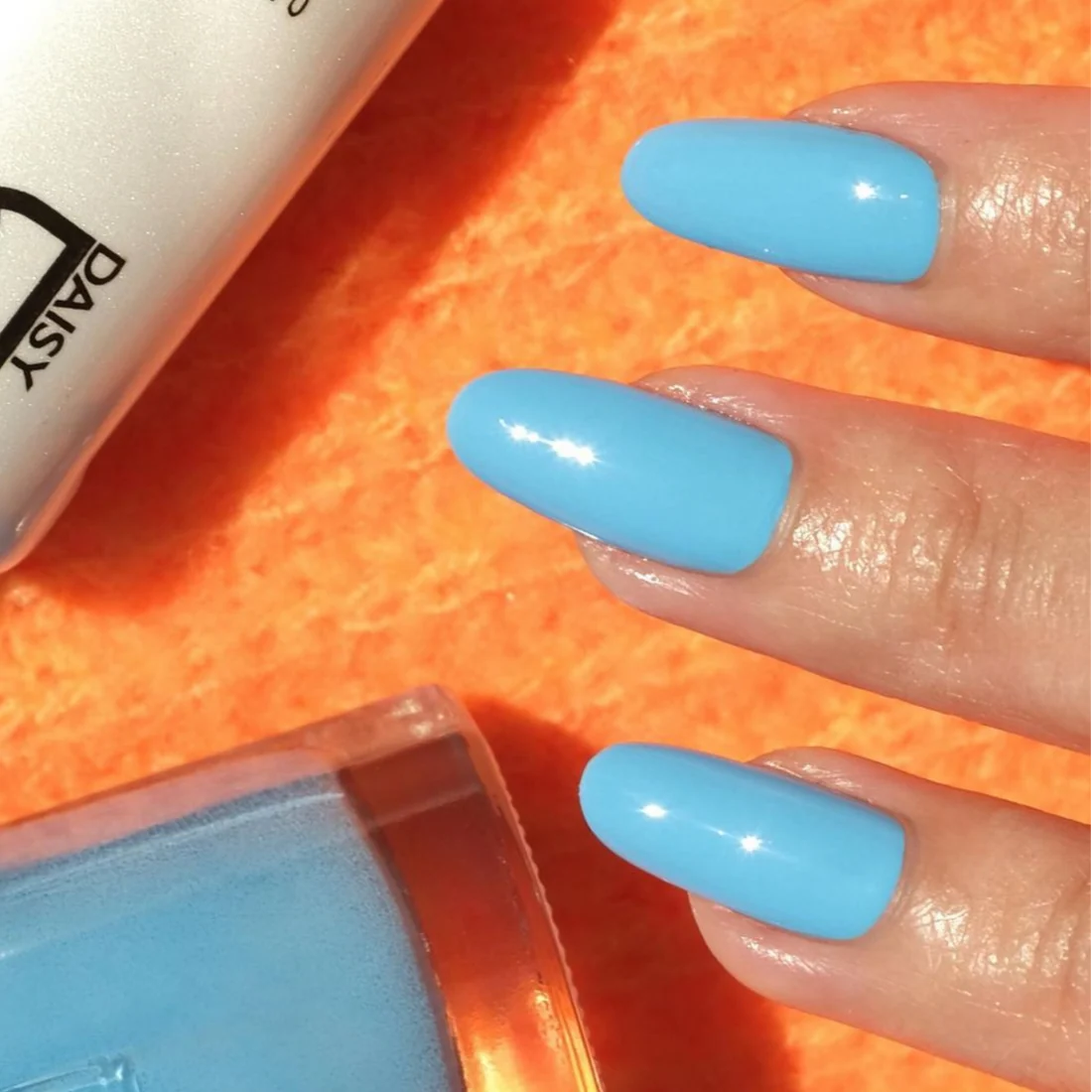 Nail technician applying DND DC Blue Lake 530 gel polish with a brush for even coverage.