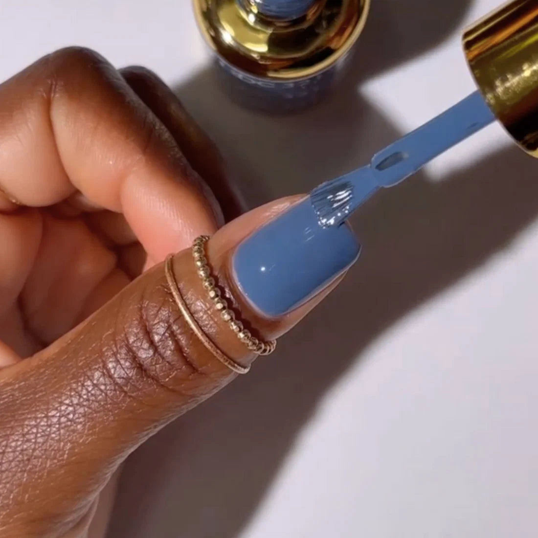 Manicure featuring DND DC Goodie Bag #321 painted on natural nails in a denim blue tone