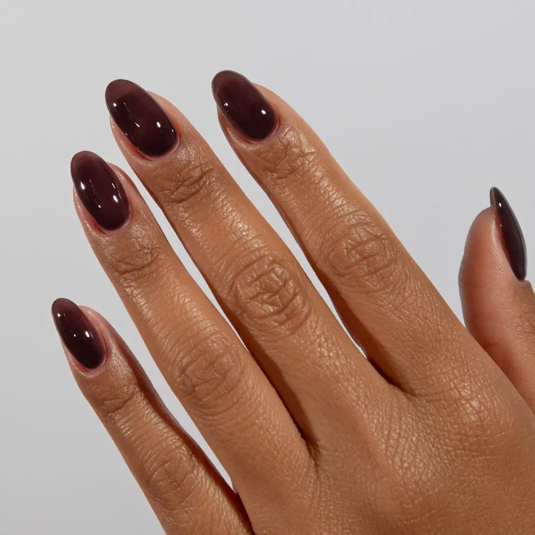 DND DC jelly gel polish on a manicured hand for Cocoa 033 showing the soft cocoa brown finish in natural light